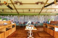 Una gran sala con mesas y sillas. en Tadoba Jungle Camp, en Mohurli