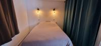 a small bed in a room with green curtains at Maison 4 A 6 Personnes in Belleville-sur-Mer