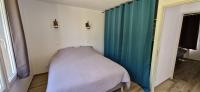 a bed in a room with a blue curtain at Maison 4 A 6 Personnes in Belleville-sur-Mer