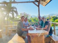 バニュウェダンにあるEco Moringa Gardenの木のテーブルに座る人々