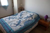 a bed with a blue and white blanket on it at Estaque Cozy nest with a magical view of the sea in Marseille