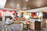 Un vestíbulo de hotel con sofás, mesas y sillas. en Ramada by Wyndham Grand Forks, en Grand Forks