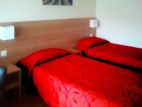two beds in a hotel room with red covers at VVF Urrugne Saint-Jean-de-Luz Côte Basque in Urrugne