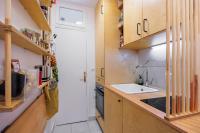a small kitchen with wooden cabinets and a sink at Veeve - The Steps to Sacré Coeur in Paris