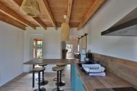 a kitchen with a wooden ceiling and a counter with stools at Gîte Louannec - Ty Bleiz in Louannec