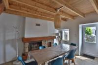 a dining room with a table and chairs and a fireplace at Gîte Louannec - Ty Bleiz in Louannec