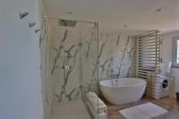 a bathroom with a tub and a glass shower at Gîte Louannec - Ty Bleiz in Louannec
