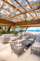 een paviljoen met stoelen en tafels op het strand bij Xeliter Green One Playa Dorada in San Felipe de Puerto Plata