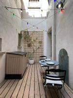 an outdoor patio with a table and chairs and lights at Mes à Moi in Pezenas - Studio &amp; patio privatif - O Pitchoun in Pézenas