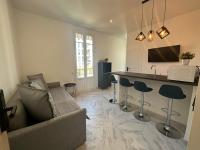 a living room with a couch and a bar with stools at La maison de Giulia Menton in Menton