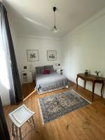 a bedroom with a bed and a table and a rug at Ferme de Maillezais in LʼHoumeau