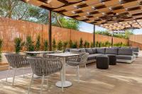 un patio con sofá, mesas y sillas en Wyndham Residences Alvor Beach, en Alvor