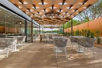 un restaurante con mesas y sillas bajo el techo en Wyndham Residences Alvor Beach, en Alvor