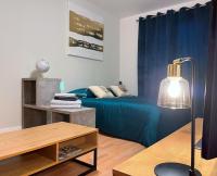 a room with a bed and a table with a lamp at Le Jockey - SIPCO Immobilier - Centre in Saint Lo