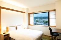 a bedroom with a bed and a desk and a window at 初音(はつね) in Kyoto