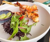 een bord met garnalen en een salade bij Amora Beach Resort Phuket in Bang Tao Beach