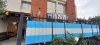 un edificio con una valla y una señal en él en avellaneda suites, en Río Gallegos