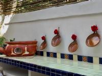 a counter with three vases and a purse on a wall at Hotel Boutique casa la Malagueña in San Agustinillo
