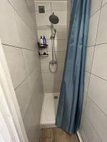 a shower with a blue shower curtain in a bathroom at Cozy home&amp;garden (Paris&#47;Disney) in Noisy-le-Sec