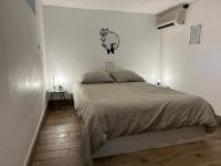 a white bedroom with a bed and a table at Cozy home&amp;garden (Paris&#47;Disney) in Noisy-le-Sec