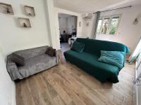 a living room with a green couch and a chair at Cozy home&amp;garden (Paris&#47;Disney) in Noisy-le-Sec