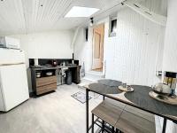 a kitchen with a refrigerator and a table with chairs at Bluepart 4 personnes in Chalons en Champagne