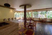 een eetkamer met een tafel, stoelen en ramen bij Senses Havelock resort in Havelock Island