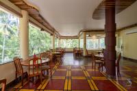 een eetkamer met tafels en stoelen en ramen bij Senses Havelock resort in Havelock Island