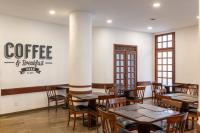 a restaurant with tables and chairs and a sign that reads coffee and restaurants at DELPLAZA Timbiras São Paulo in São Paulo