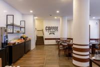a restaurant with tables and chairs and a coffee bar at DELPLAZA Timbiras São Paulo in São Paulo