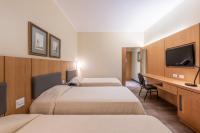 a hotel room with two beds and a desk at DELPLAZA Timbiras São Paulo in São Paulo