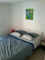 a bedroom with two beds and a painting on the wall at L&#39;OASIS maisonnette centre ville 3 chambres terrasse espace vert privé parc sainte croix center parc 20 minutes in Sarrebourg