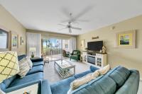ein Wohnzimmer mit einem blauen Sofa und einem Fernseher in der Unterkunft Amalfi Coast 113B - Steps from the Beach 2BD 2BA in Destin