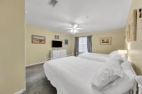 ein Schlafzimmer mit zwei Betten und einem Flachbildfernseher in der Unterkunft Amalfi Coast 113B - Steps from the Beach 2BD 2BA in Destin