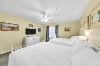 ein Schlafzimmer mit zwei Betten und einem Flachbildfernseher in der Unterkunft Amalfi Coast 113B - Steps from the Beach 2BD 2BA in Destin