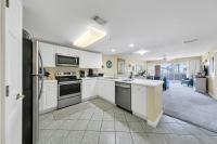 eine Küche mit weißen Schränken und Geräten sowie ein Wohnzimmer in der Unterkunft Amalfi Coast 113B - Steps from the Beach 2BD 2BA in Destin