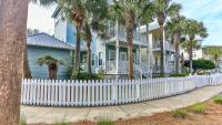 ein weißer Gartenzaun vor einem Haus mit Palmen in der Unterkunft Biglows Bungalow - About a quarter mile to PRIVATE Neighborhood Beach Access, Pet Friendly, Community Pool in Destin