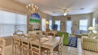 ein Esszimmer und ein Wohnzimmer mit Tisch und Stühlen in der Unterkunft Biglows Bungalow - About a quarter mile to PRIVATE Neighborhood Beach Access, Pet Friendly, Community Pool in Destin