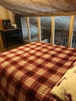 a bed with a checkered blanket in a room at Chalet au pied des pistes du Cambre d Aze in Saint-Pierre-dels-Forcats