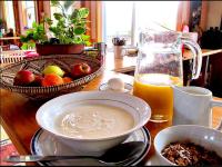 einen Tisch mit einer Schüssel Suppe und einem Glas Orangensaft in der Unterkunft Cabot Shores in Indian Brook