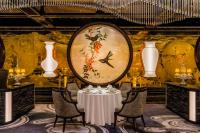 Un comedor con una mesa y un gran cuadro en la pared. en Grand Lisboa Palace Macau, en Macau