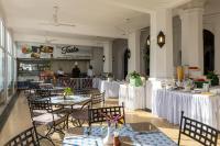 Un restaurante con mesas y sillas y un buffet. en Sentrim Castle Royal Hotel, en Mombasa