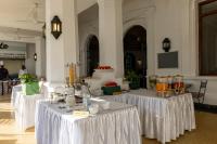 Un grupo de mesas con manteles blancos en un edificio. en Sentrim Castle Royal Hotel, en Mombasa