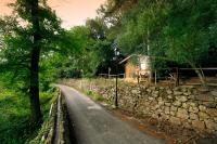 a road with a stone wall and a house at Complejo Rural Huerta Grande in Algeciras