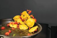 Un plato de comida con pasta amarilla y verduras. en Adesso Hotel, en Roma