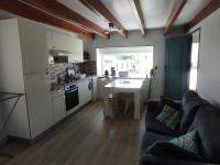 a kitchen and living room with a couch and a table at Le gîte de ty stumo1 in Neulliac