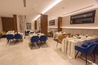 a dining room with tables and blue chairs at Skyline Hotel & Suites in Tabuk