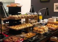 a buffet line with various types of bread and pastries at Sheraton São Paulo WTC Hotel in Sao Paulo