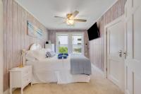 ein Schlafzimmer mit einem Bett und einem Deckenventilator in der Unterkunft Beachy Keen, North Myrtle Beach beach single-family house, 150 feet to ocean! Pets welcome! in Myrtle Beach