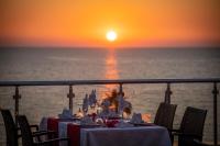 a dinner table on a cruise ship with the sunset at Senza Grand Santana Hotel - Ultra All Inclusive in Mahmutlar